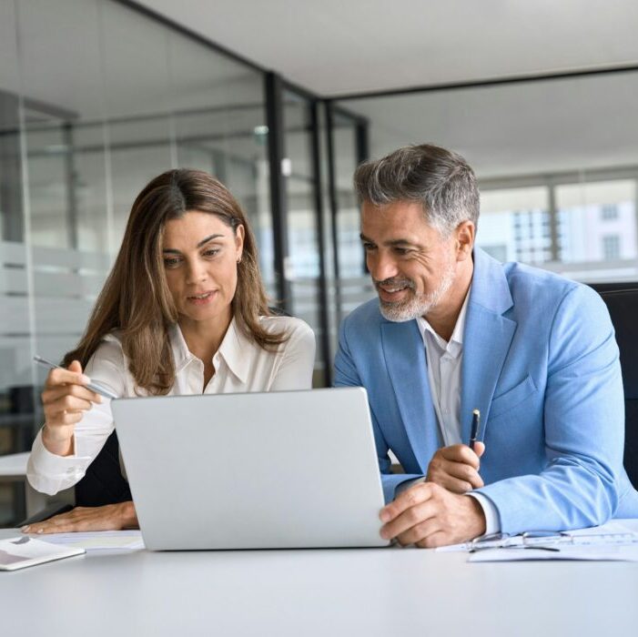 Zwei Mitarbeiter der Werbeagentur in Zürich planen eine Strategie am Laptop