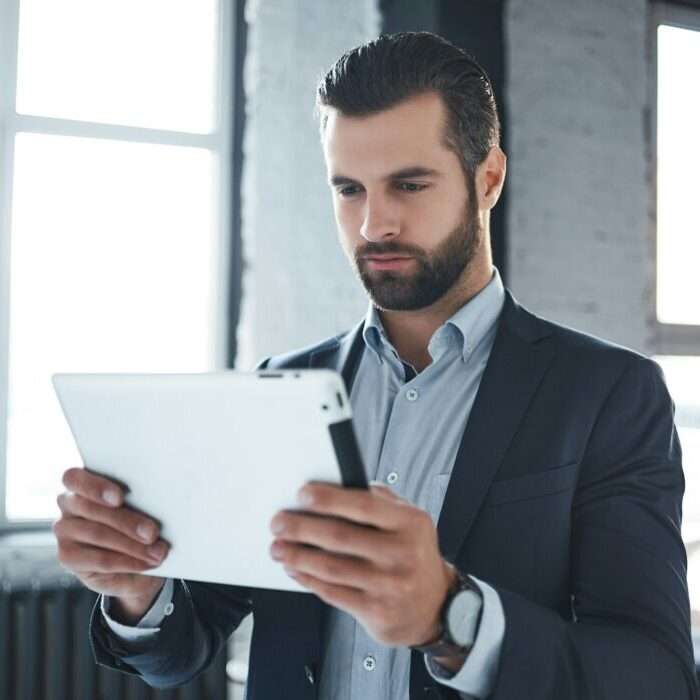 Ein Unternehmer sieht seine neue Marke am Tablet an